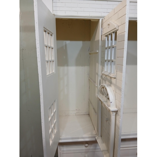 260 - Painted wooden wardrobe in the form of a Doll's House with three doors over three short drawers. {H ... 