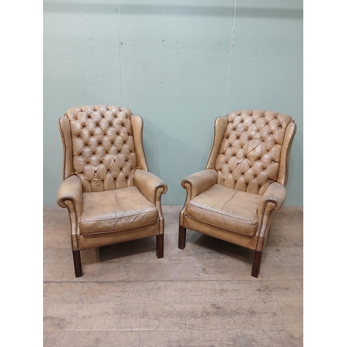 262 - Pair of deep buttoned leather upholstered wingback armchairs with studded detail.  {H 105cm x W 75cm... 