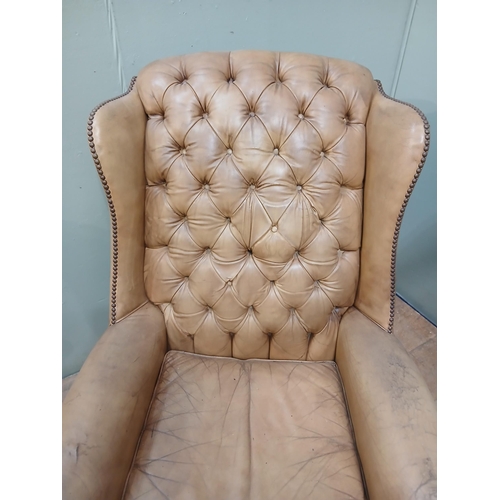 262 - Pair of deep buttoned leather upholstered wingback armchairs with studded detail.  {H 105cm x W 75cm... 