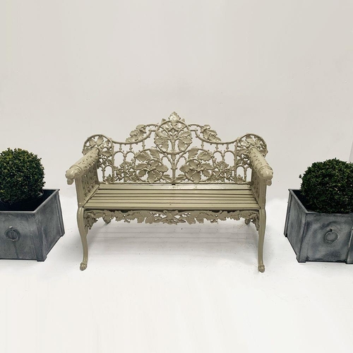 37 - Cast iron two seater garden bench with arms terminating in Dog's head with oak and ivy decoration in... 