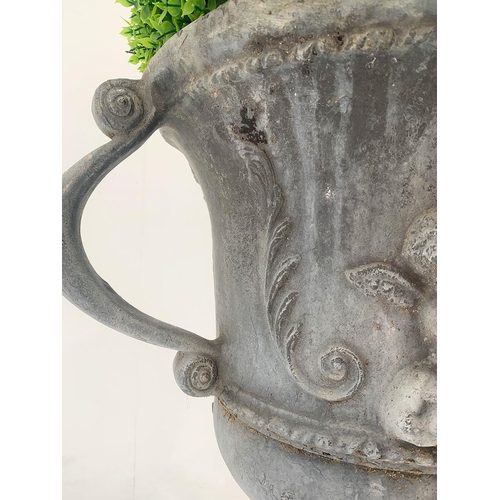 38 - Lead garden oval urn on base with cherub decoration and scrolled handles. {76 cm H x 50 cm W x 38 cm... 