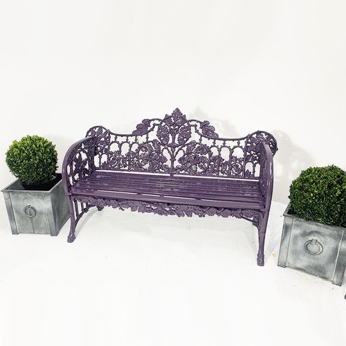 44 - Cast iron two seater garden bench with curved arms and oak and ivy decoration in the Coalbrookdale s... 