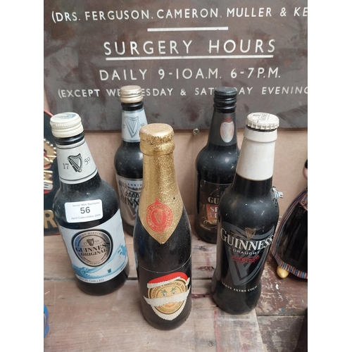 56 - Five bottles of Guinness incuding a Christmas bottle and Year 2000 bottle. {23 cm H x 7 cm Dia.}.