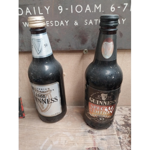 56 - Five bottles of Guinness incuding a Christmas bottle and Year 2000 bottle. {23 cm H x 7 cm Dia.}.
