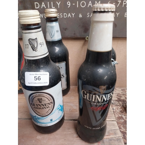 56 - Five bottles of Guinness incuding a Christmas bottle and Year 2000 bottle. {23 cm H x 7 cm Dia.}.