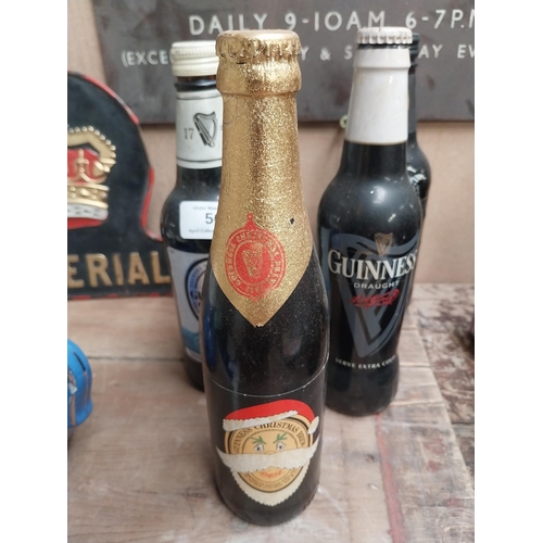 56 - Five bottles of Guinness incuding a Christmas bottle and Year 2000 bottle. {23 cm H x 7 cm Dia.}.