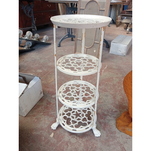 31 - Cast iron four tier plant stand with claw feet.  {H 70cm x Dia 35cm}. NOT ON SITE FOR VIEWING