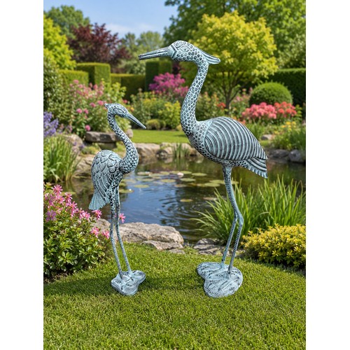 7 - Two bronzed metal cranes. {96 cm H x  52 cm W x 27 cm D} and {80 cm H x 32 cm W x 18 cm D}.