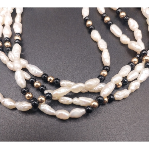 59 - 14ct gold seed pearl and onyx  four strand bracelet. {18 cm}.