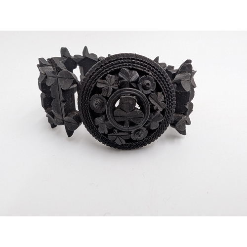 37 - Five 19th C. Irish bog oak brooches, two bracelets and two cross pendants.