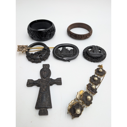 42 - Three 19th C. Irish bog oak bracelets, three brooches and single cross pendant.