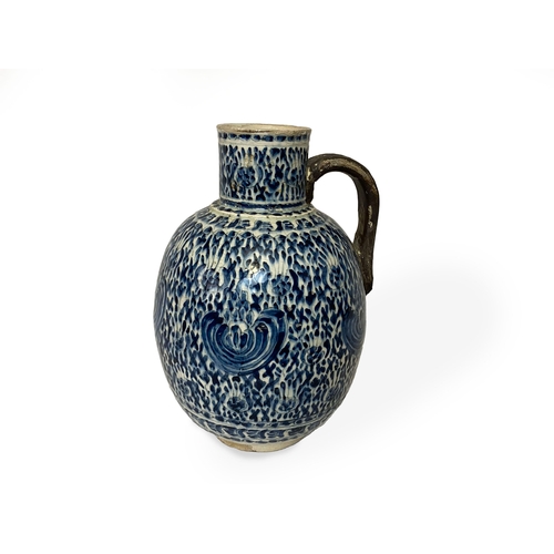 85 - AN OTTOMAN GLAZED POTTERY JUG, 18TH CENTURY, KUTAHYA, TURKEY

Of graceful bulbous form enhanced by a... 