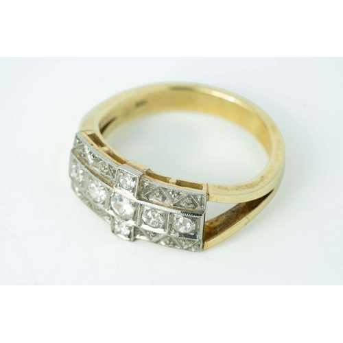 65 - A Cross-Shaped Diamond Gold Ring 

A diamond ring, set with round diamonds in a cross-shaped millgra... 