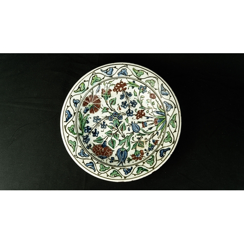 57 - AN IZNIK POLYCHROME POTTERY DISH, TURKEY, CIRCA 
Of rounded form, decorated in underglaze cobalt blu... 