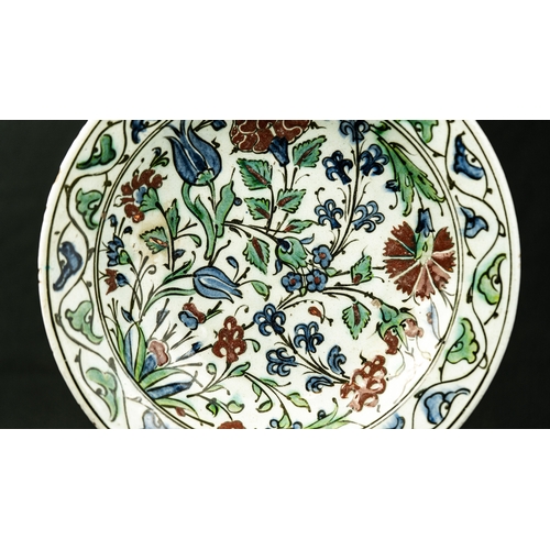 57 - AN IZNIK POLYCHROME POTTERY DISH, TURKEY, CIRCA 
Of rounded form, decorated in underglaze cobalt blu... 