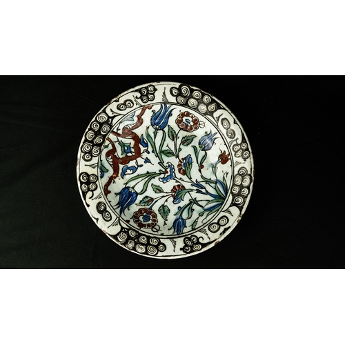 58 - AN IZNIK POLYCHROME POTTERY DISH, TURKEY, CIRCA 

Of rounded form, decorated in underglaze cobalt bl... 