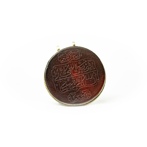 10 - SILVER FRAMED AGATHE CIRCULAR PENDANT HALDILI Of round form, the agate surface engraved with Arabic ... 