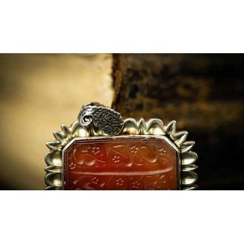 13 - A RECTANGULAR FORM SILVER FRAMED AGATE PENDANT Of square form, Arabic inscription engraved in nas’ta... 