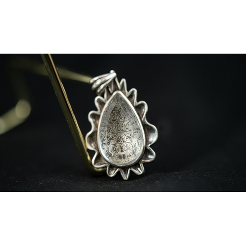 21 - A DROP FORM ENGRAVED ROCK CRYSTAL PENDANT, IRAN Of tear shape, the crystal surface engraved with Ara... 