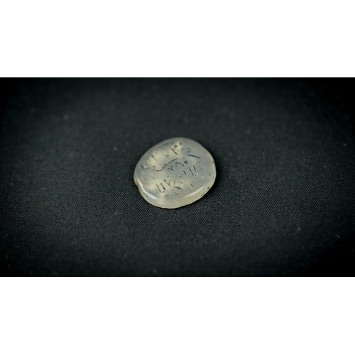 34 - A CARVED ROCK CRYSTAL TALISMANIC STONE Of round form, depicting a mosque dome and two minarets and e... 