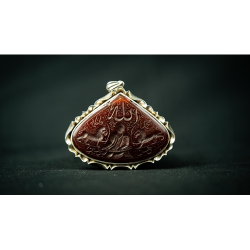 4 - A SILVER FRAMED CARVED AGATE PENDANT IRAN, TAHRAN. Of wide drop form, depicting Imam Ali with Zulfik... 