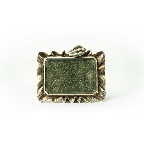 7 - A RECTANGULAR FORM SILVER FRAMED GREEN JADE PENDANT Of square form, the jade surface engraved with A... 