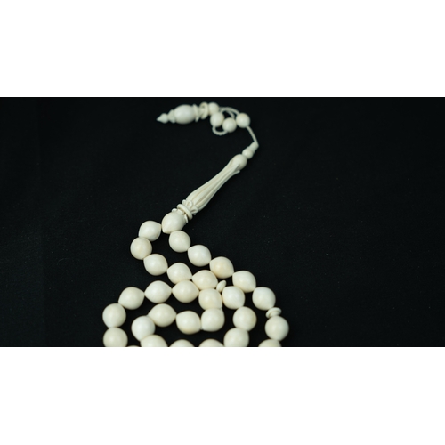 56 - BONE PRAYER BEADS, The tasbih strung  with 33 bone ovoid  beads, flat stops, narrowing and  stylised... 