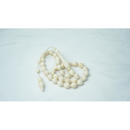 56 - BONE PRAYER BEADS, The tasbih strung  with 33 bone ovoid  beads, flat stops, narrowing and  stylised... 