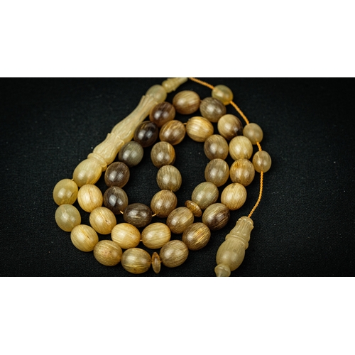 62 - The tasbih strung  with 33  spherical  beads, flat stops, narrowing and stylised elongated tulip ima... 