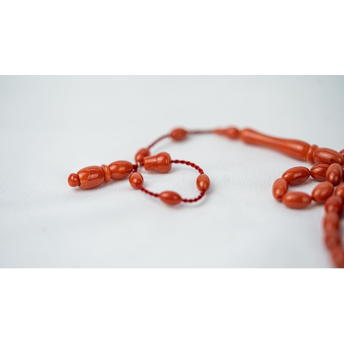 71 - A SET OF CORAL BEADS AND TURBAN FINIAL, A coral prayer beads, 99 beads for Muslim prayers, set in it... 