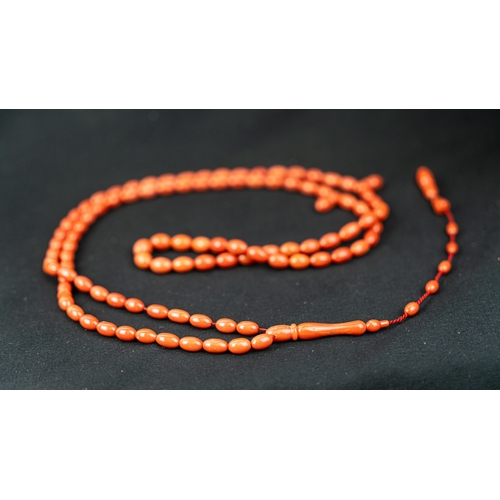 71 - A SET OF CORAL BEADS AND TURBAN FINIAL, A coral prayer beads, 99 beads for Muslim prayers, set in it... 