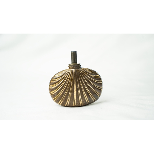 124 - A SHELL- SHAPED TOMBAK POWDER FLASK OTTOMAN TURKEY, 19TH CENTURY, Comprising a small shell-shaped To... 