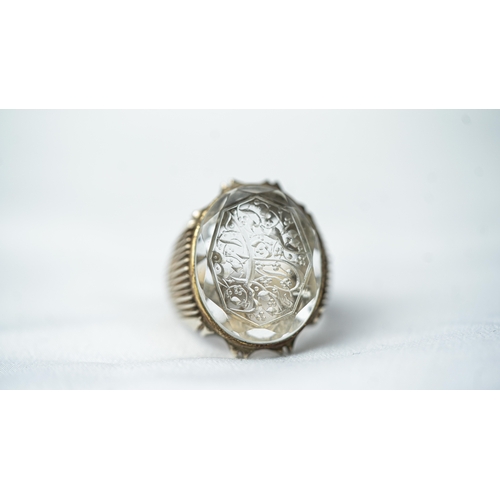 135 - A SILVER FRAMED INTAGLIO ROCK CRYSTAL RING, The oval domed rock crystal ring with Arabic inscription... 