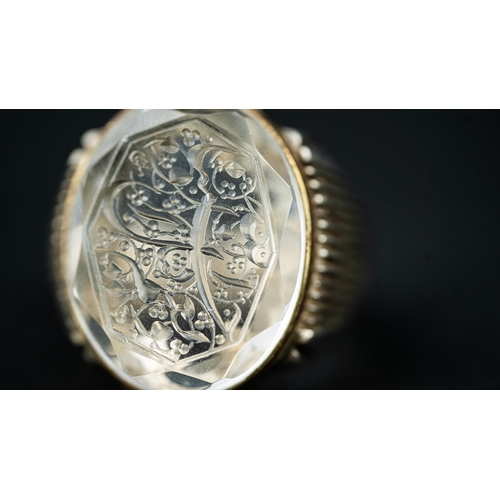 135 - A SILVER FRAMED INTAGLIO ROCK CRYSTAL RING, The oval domed rock crystal ring with Arabic inscription... 