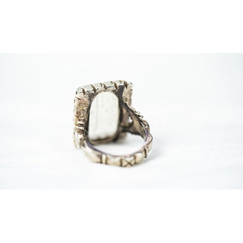 136 - AN ARABIC INSCRIPTION CARVED ROCK CRYSTAL SEAL RING, Of square form, stepped rock crystal engraved w... 