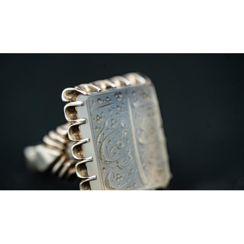 136 - AN ARABIC INSCRIPTION CARVED ROCK CRYSTAL SEAL RING, Of square form, stepped rock crystal engraved w... 