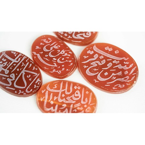 140 - A SET OF FIVE AGATE STONES, Of oval forms, a group of five hard stones, engraved with Qur’anic inscr... 