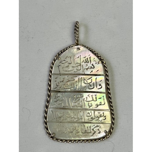 151 - A MOTHER OF PEARL PENDANT, OTTOMAN TURKEY, Of oval form, executing 5ll. Of Arabic calligraphy, Qur’a... 