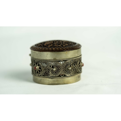 153 - A SILVER FILIGREE SNIFF BOX WITH ROSEWOOD LID, Of rounded form, the silver body adorned with a metic... 