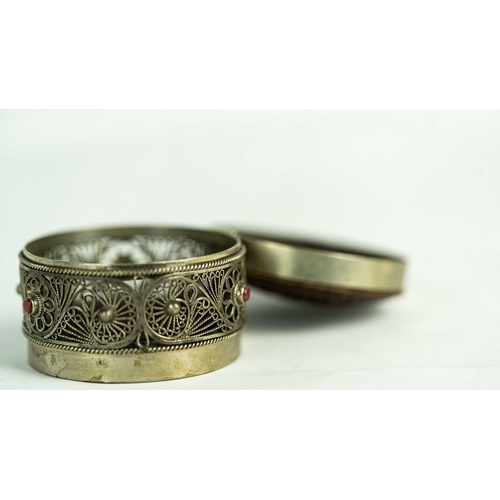 153 - A SILVER FILIGREE SNIFF BOX WITH ROSEWOOD LID, Of rounded form, the silver body adorned with a metic... 