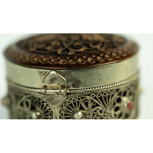 153 - A SILVER FILIGREE SNIFF BOX WITH ROSEWOOD LID, Of rounded form, the silver body adorned with a metic... 