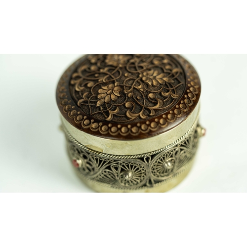 153 - A SILVER FILIGREE SNIFF BOX WITH ROSEWOOD LID, Of rounded form, the silver body adorned with a metic... 