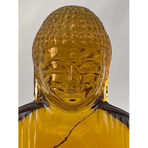 74 - AN AMBEROID STYLIZED BUDDHA ORNAMENT, A serene Buddha, sculpted from  amberoid, resting upon a lotus... 