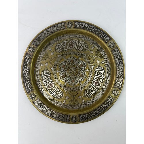 1 - A  BRASS ENGRAVED TRAY

Of circular shape, resting on a flat and plain base, rising to an everted ri... 