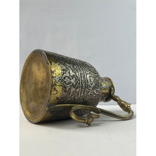 2 - A BRONZE BRASS JUG

Of cylindrical form, with narrowing shoulders, rising to a tubular neck, an S-sh... 