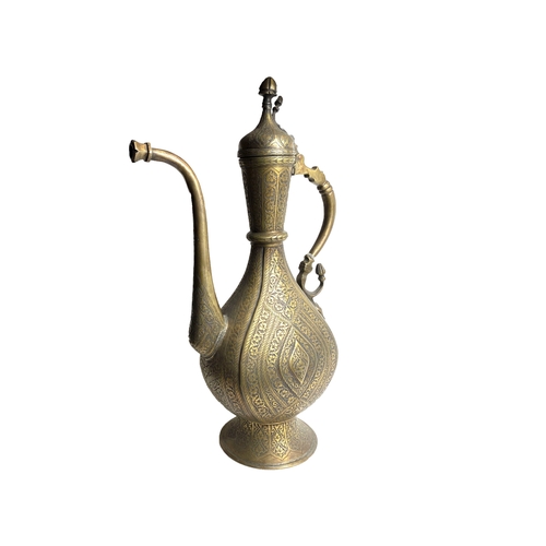 7 - A 19TH 
CENTURY SAFAVID STYLE BRASS EWER

Of tear-drop shape, resting on circular sprayed foot, risi... 