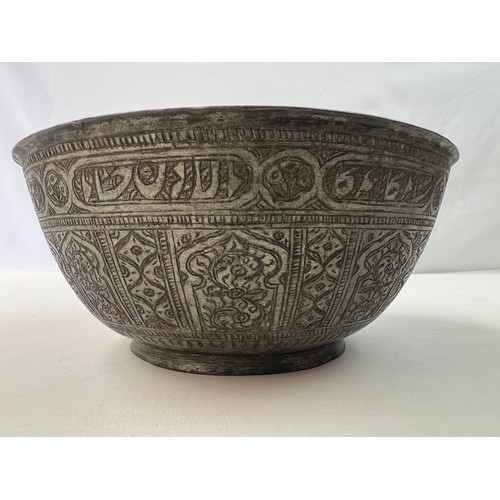 24 - A BRASS ENGRAVED  BOWL
Of rounded form, resting on short foot, engraved with panels of interlocking ... 