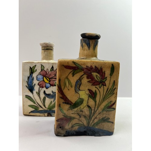 44 - A PAIR OF IZNIK STYLE POTTERY PARFUME BOTTLES
Of squared form with narrow cylindrical necks and stop... 