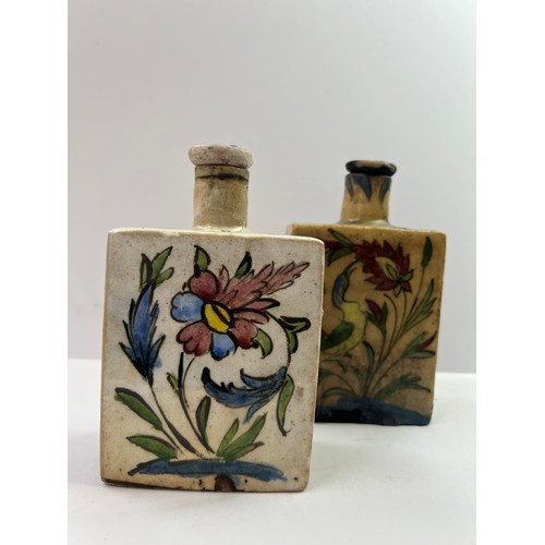 44 - A PAIR OF IZNIK STYLE POTTERY PARFUME BOTTLES
Of squared form with narrow cylindrical necks and stop... 