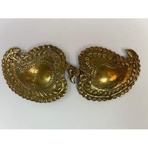 46 - A BRASS BELT BUCKLE
Containing
 two detachable plaques, each of drop-like shape with an upward-turne... 